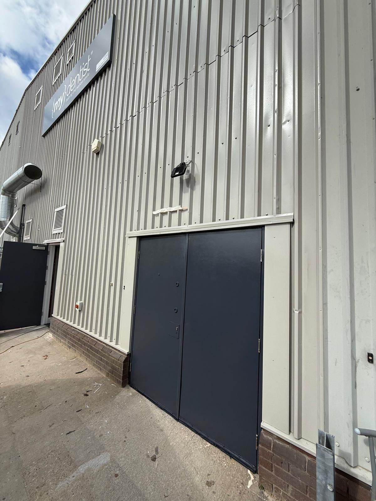 Metal-clad commercial unit with a sprayed door