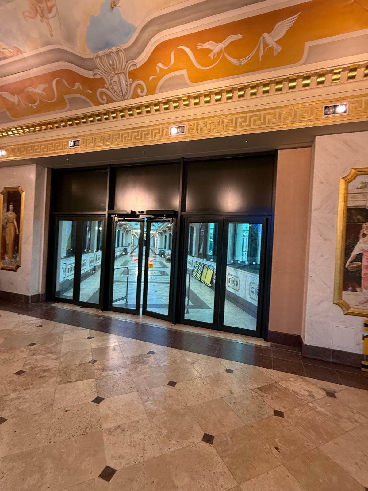 Glazed entrance doors beneath an ornate painted ceiling