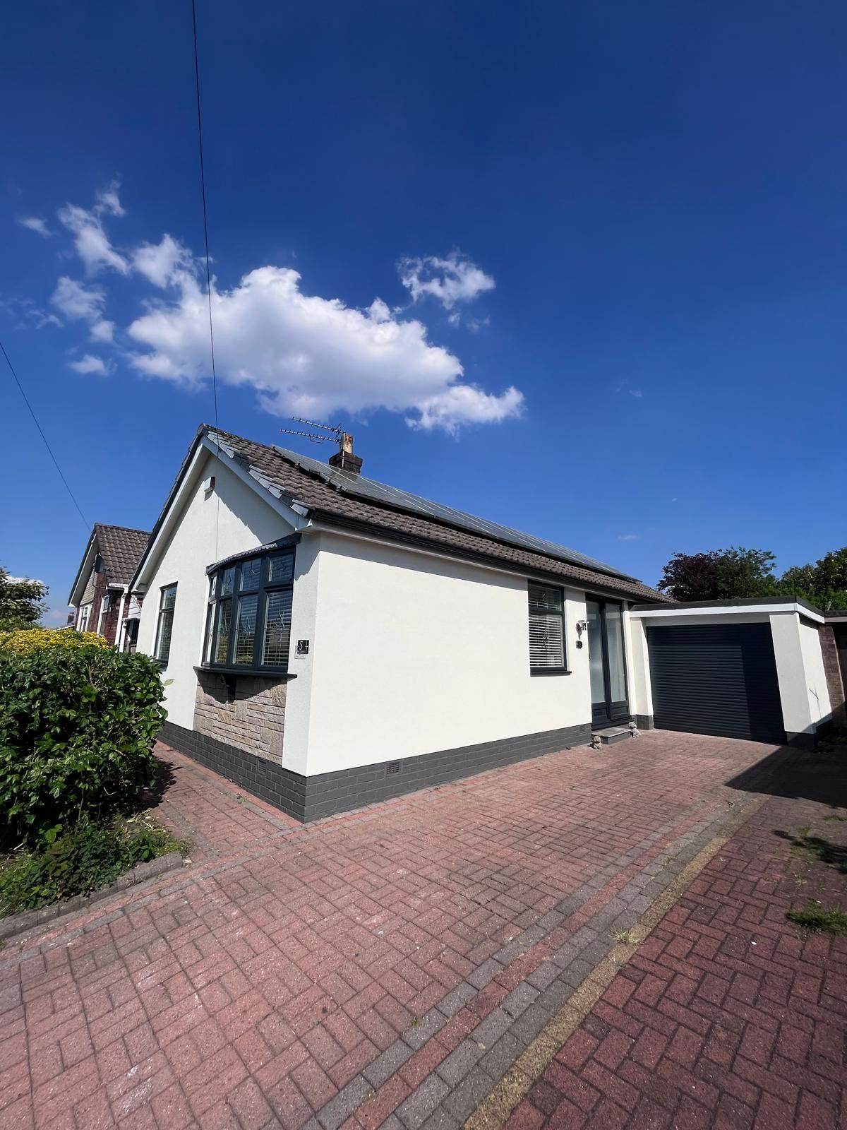 White rendered bungalow with black window frames