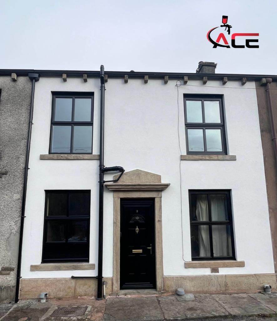 White rendered stone cottage with black front door