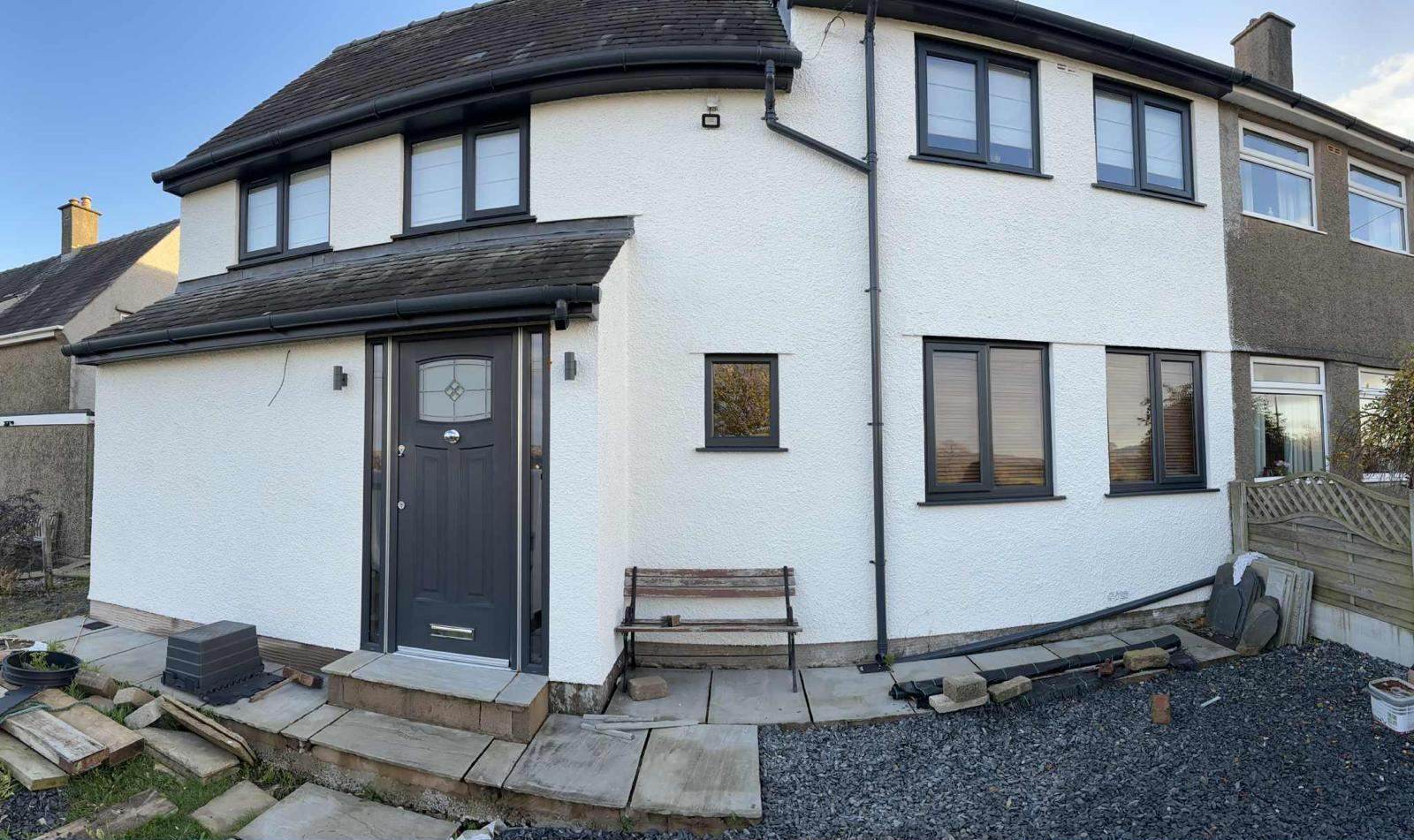 White semi-detached house with black windows and door