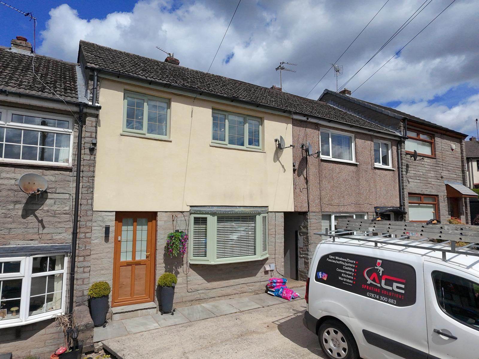 Row of stone terraced houses with sage green window frames and the Ace Spraying Solutions van parked outside
