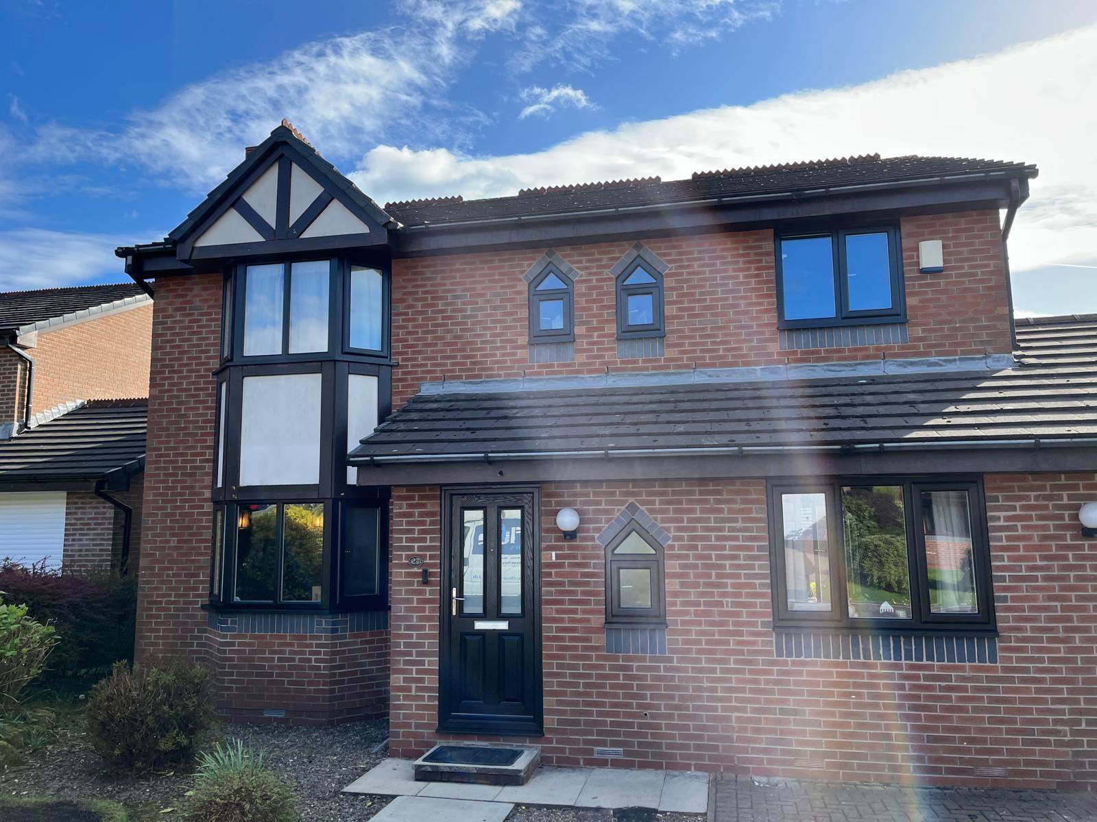 Brick house with tudor-style gable and black window frames