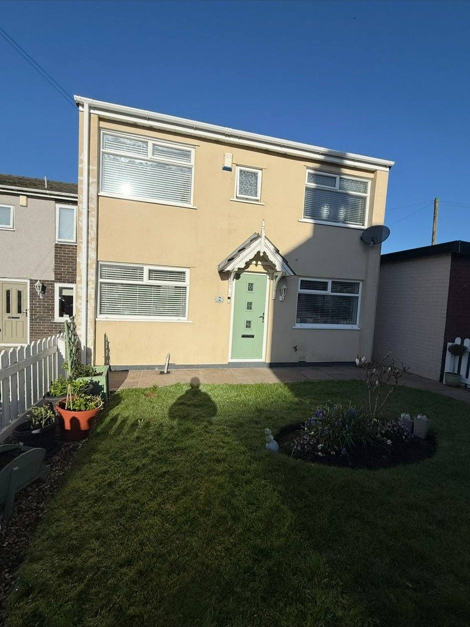 Same semi-detached house with fresh pale cream render and a sage green front door