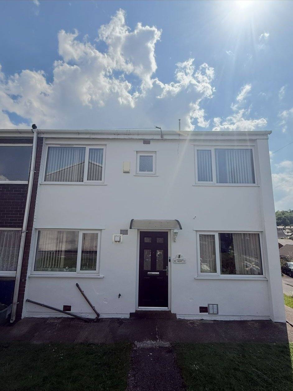 Same terraced house with fresh white render