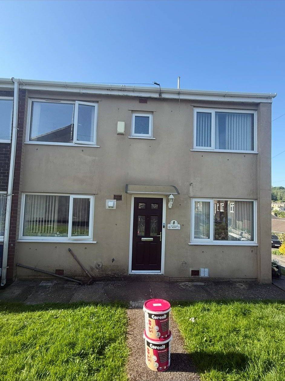 Terraced house with dirty grey-tan render